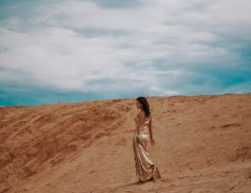 femme dans le désert portant une robe marocaine