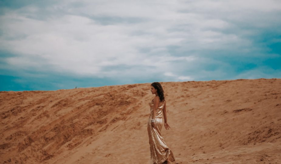 femme dans le désert portant une robe marocaine